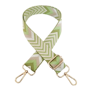 Close-up of adjustable woven strap with green chevron pattern and gold metal hooks