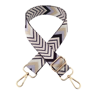Close-up of woven bag strap with purple chevron pattern and golden lobster clasps