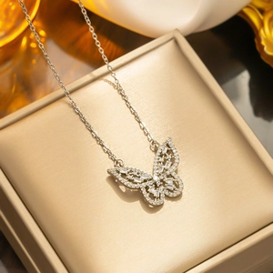 Hollow butterfly pendant necklace with shimmering cubic zirconia on champagne jewelry pad