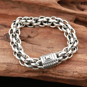 Bracciale a catena in argento da uomo con chiusura testurizzata su una base di legno