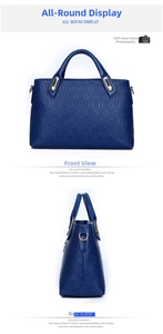 Detail of dark blue women's handbag featuring textured oval embossing and gold hardware