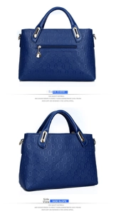 Detail view of navy blue embossed leather handbag featuring golden hardware and rear zip pocket