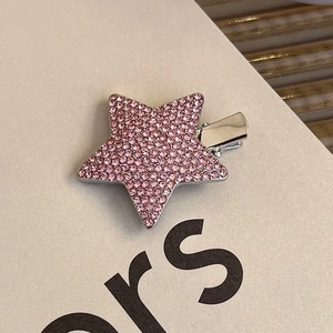 Detailed macro view of star shaped hair clip featuring pink rhinestones and silver metal base
