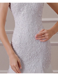 Detailed macro view of silver-white floral lace embroidery on a mermaid bridal gown