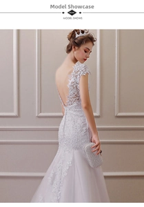 Detailed view of the backless lace bodice with elegant floral embroidery on a white dress