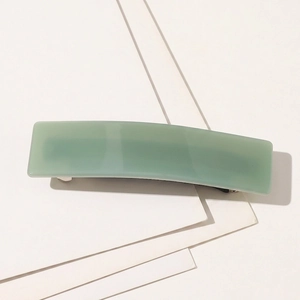 Gros plan d'une pince à cheveux rectangulaire vert menthe en acétate fini brillant