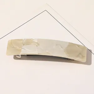 Détail de la pince à cheveux rectangulaire en acétate avec texture marbre crème