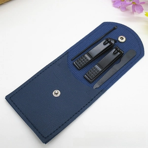 Close-up of black matte nail clippers set in a blue faux leather case with silver snap