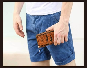 Brown long zipper wallet with vintage US dollar bill print held by a male model