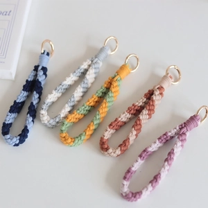Five handmade woven cotton wristlet keychains with metallic clasps in various striped colors