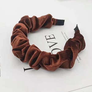 Detail view of brown pleated corduroy headband on a vintage magazine background