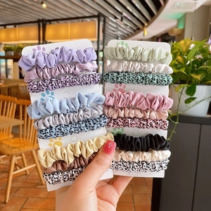 Set of leopard print and solid color fabric scrunchies displayed on display cards
