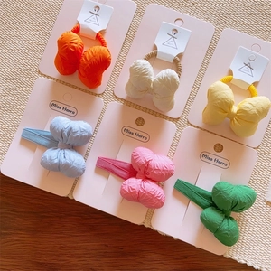 Kids' macaron cotton-filled bow hair clips and ties set on a wooden surface