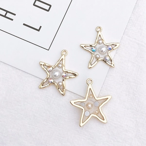 Close-up of golden star-shaped pendants featuring embedded white pearls and crystals