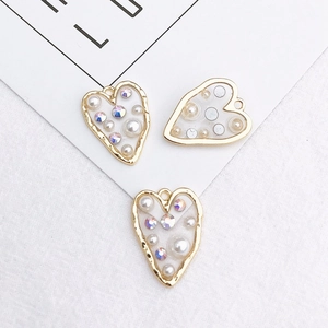 Detail of heart-shaped DIY jewelry charms with pearls and sparkling rhinestones