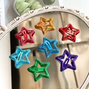 Set of seven colorful glitter star-shaped Y2K BB hair clips on a vintage mirror
