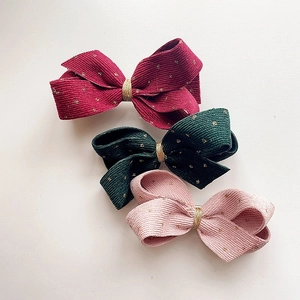 Three-piece set of corduroy bow hair clips in red, green, and pink with gold dots