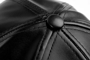 Macro detail of the crown and stitching on the black leather baseball cap for men