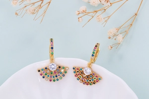 Detail of fan-shaped gold earrings with colorful zircon micro-pave and white center stone