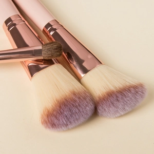 Detail of soft gradient purple bristles and rose gold ferrule on mini makeup brushes