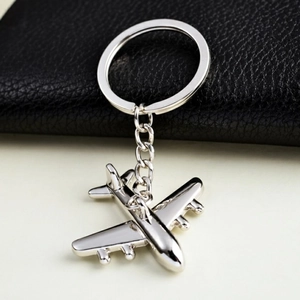 Close-up of a silver metal fighter jet keychain with a polished finish and a link chain