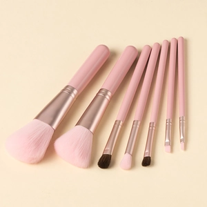 Close-up of 8-piece pink makeup brush set with various sizes on a beige background
