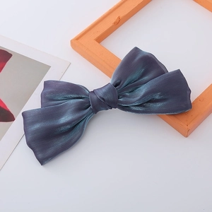 Detailed view of iridescent mermaid satin bow hair clip with luxury metallic sheen