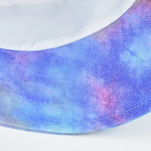 Macro shot of tie-dye bucket hat fabric showing blue and purple gradient twill texture