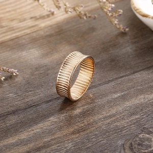 Detailed macro view of an 18K gold-plated wide band ring with vertical striped texture