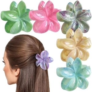 Detail showing various colors of 7cm frangipani flower hair claws with marble texture