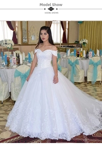 Detailed embroidery and lace applique on a white off-the-shoulder ball gown wedding dress