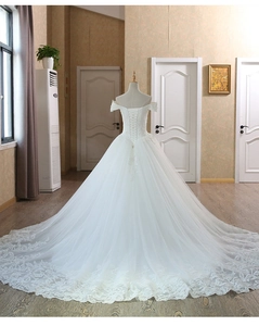 Detailed back view of a white off-shoulder bridal gown featuring lace lace-up closure and train