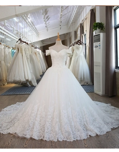 Exquisite white lace embroidery detail on the bodice of an off-the-shoulder bridal gown