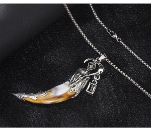 Macro shot of silver death reaper pendant with faux wolf tooth and box chain detail