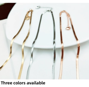 Detailed view of flat snake bone chain necklaces in gold, silver and rose gold finishes