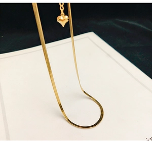 Close-up of a gold snake chain necklace featuring a polished heart-shaped pendant