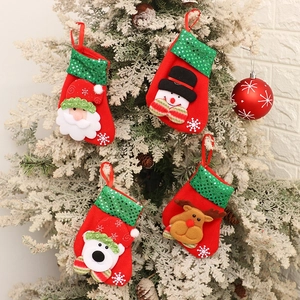 Close-up of four festive sequined Christmas stockings hanging on a tree with reindeer design