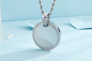 Macro detail of silver round pendant with shimmering crystal border on a twist chain