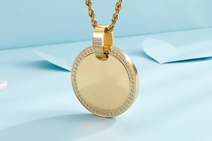 Macro shot of gold circular pendant with crystal border and twisted rope chain detail