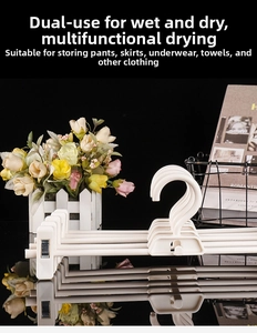 Detail of multi-functional white pants hanger with adjustable metal clips and non-slip design