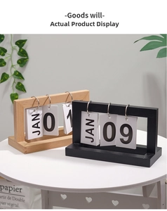 Detail of wooden flip calendar showing metal rings and date cards in a minimalist setting