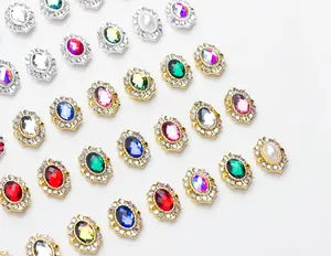 Détail de cristaux d'ongles ovales colorés avec bordures en strass sur fond blanc poli