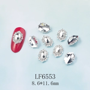 Macro d'un bijou d'ongle ovale en cristal sur ongle rouge, dimensions 8,6x11,6 mm