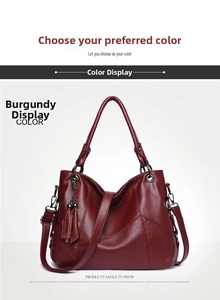 Detail view of wine red hobo bag featuring litchi texture leather and tassel charm