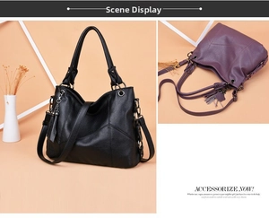 Detail view of large soft leather tote bags in black and purple with metal tassel charm