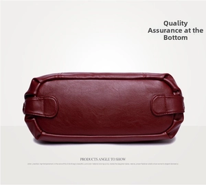 Detailed view of burgundy soft leather handbag base with reinforced stitching