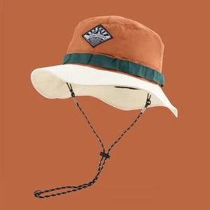 Detail of outdoor sun hat with mountain patch, contrast brim and adjustable chin cord