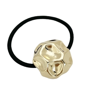 Elastic black hair tie with geometric gold metallic charm for women on white background