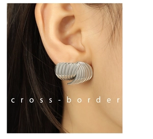 Macro detail of layered wave texture and fan shape of the silver titanium steel earring