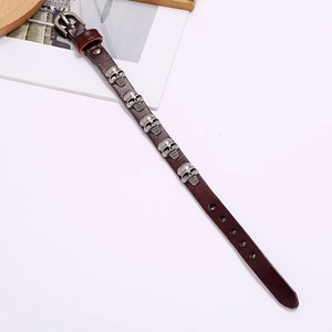 Detailed close-up of punk style brown leather bracelet with silver skull metal studs